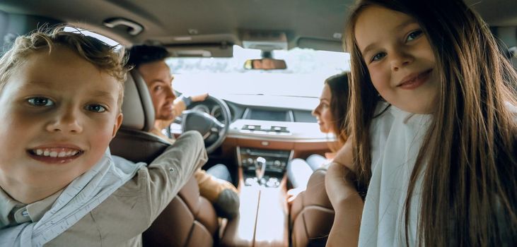 children sitting in the back seat of the car. family holiday