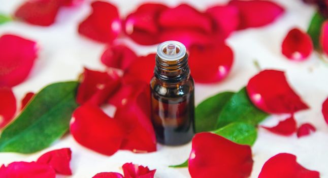 Rose essential oil in a small bottle. Selective focus. Nature.