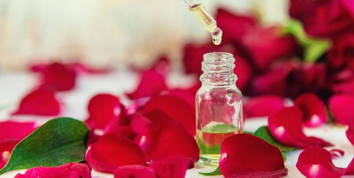 Rose essential oil in a small bottle. Selective focus. Nature.