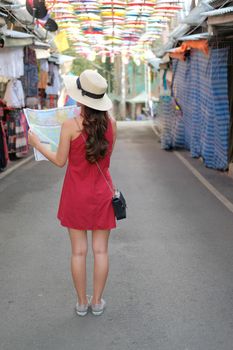 young asian woman traveler tourist with map traveling on walking street. journey trip travel concept