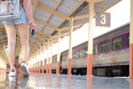 young asian woman  backpacker traveler with camera backpack at train station. journey trip travel concept