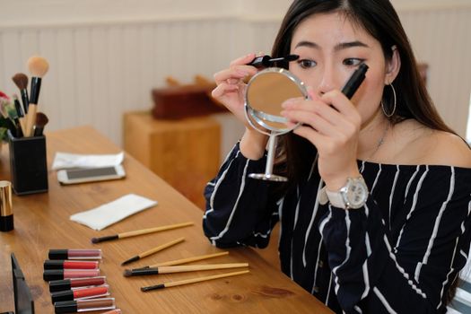 asian woman applying makeup cosmetic. make up beauty concept