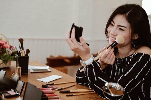 asian woman applying makeup cosmetic. make up beauty concept