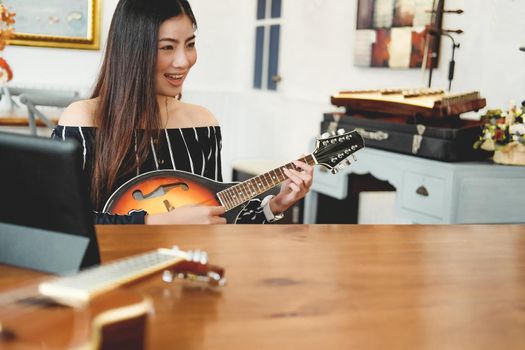 woman playing guitar at home.  leisure lifestyle concept