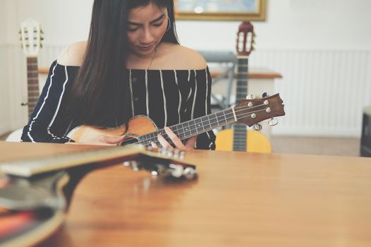 woman playing guitar at home.  leisure lifestyle concept