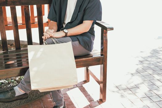 man sitting resting with shopping bags at shopping mall. consumerism lifestyle