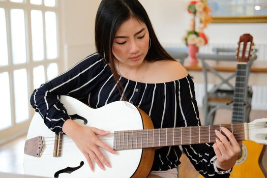 woman playing guitar at home.  leisure lifestyle concept