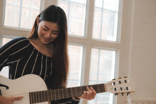 woman playing guitar at home.  leisure lifestyle concept