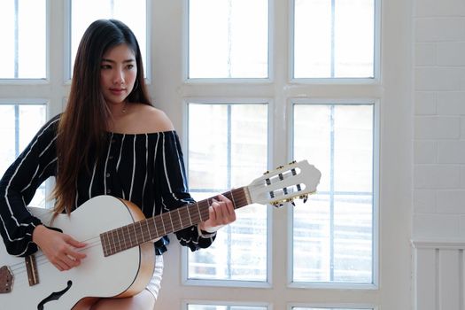 woman playing guitar at home.  leisure lifestyle concept