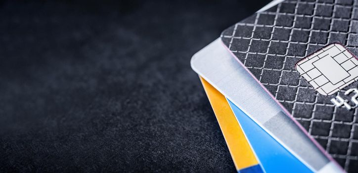 Credit cards stack on dark background with copyspace