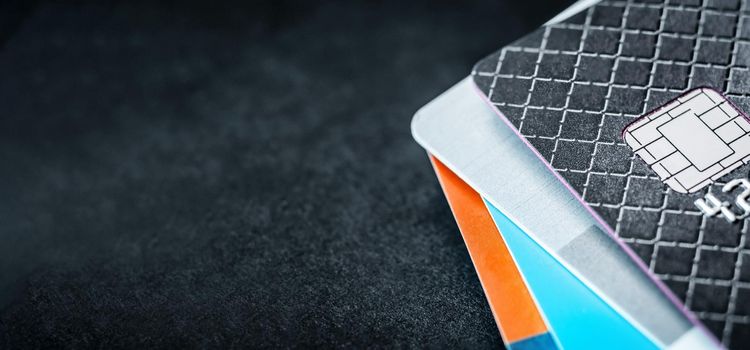 Credit cards stack on dark background with copyspace