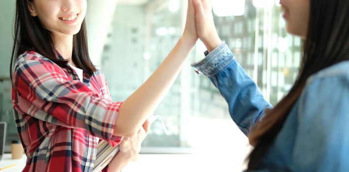 girl teenager giving high five touching hands together. teamwork friendship amity concept