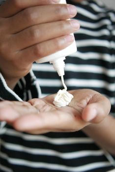 Close up of young men applying sunscreen cream ,