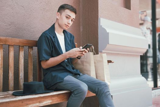 man using mobile smart phone with paper shopping bags. consumerism lifestyle