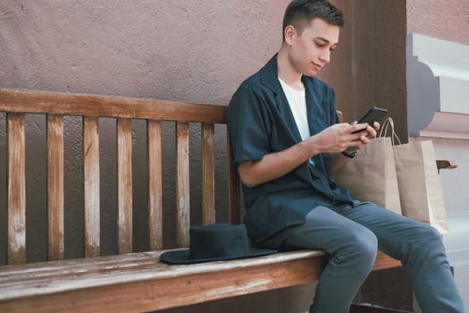 man using mobile smart phone with paper shopping bags. consumerism lifestyle