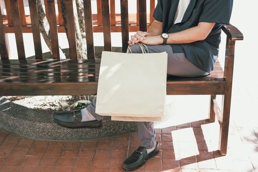 man sitting resting with shopping bags at shopping mall. consumerism lifestyle