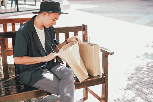 man looking inside shopping bag. consumerism lifestyle