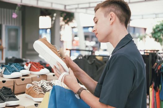 man holding shopping bags choosing shoes at store shop mall