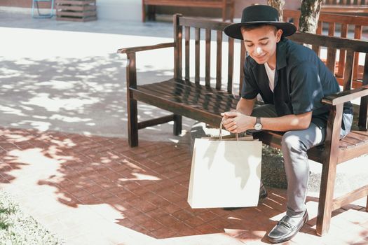 man sitting resting with shopping bags at shopping mall. consumerism lifestyle