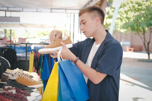 man holding shopping bags choosing shoes at store shop mall