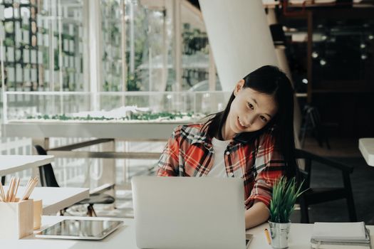 woman girl teenager freelancer talking on phone working on computer at workplace