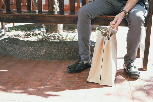 man sitting resting with shopping bags at shopping mall. consumerism lifestyle