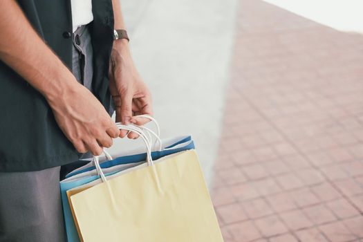 man with shopping bags at shopping mall. consumerism lifestyle