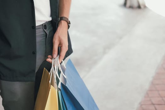 man with shopping bags at shopping mall. consumerism lifestyle