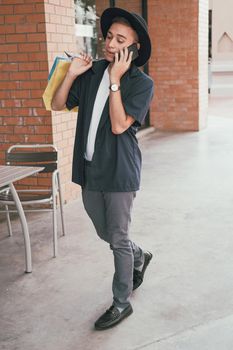 man holding paper shopping bags & talking on mobile smart phone. consumerism lifestyle