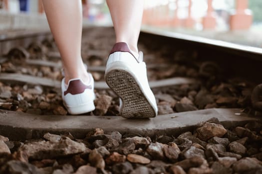 young woman traveler with white sneakers at train station. journey trip travel concept