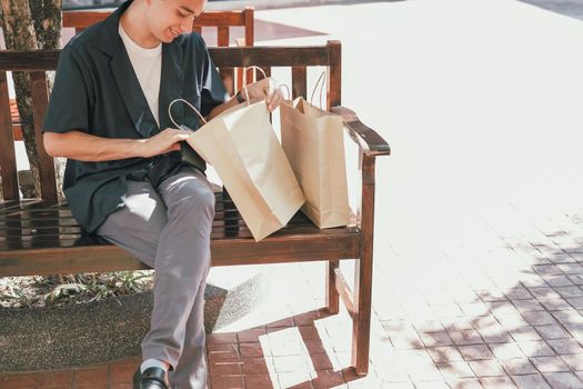 man looking inside shopping bag. consumerism lifestyle