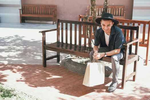 man sitting resting with shopping bags at shopping mall. consumerism lifestyle