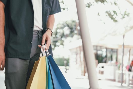 man with shopping bags at shopping mall. consumerism lifestyle