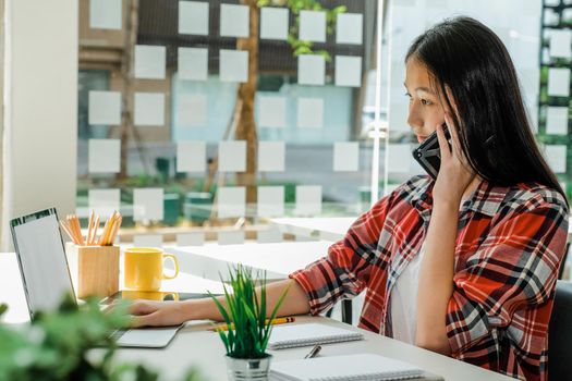 woman girl teenager freelancer talking on phone working on computer at workplace