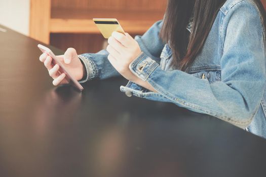 woman holding credit card using mobile smart phone for shopping online