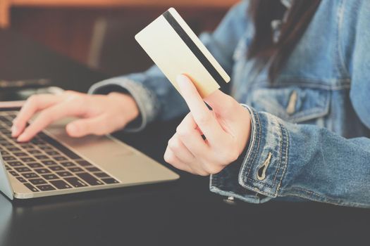 woman holding credit card using computer for shopping online