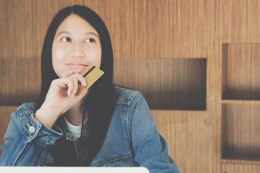 woman holding credit card using computer for shopping online