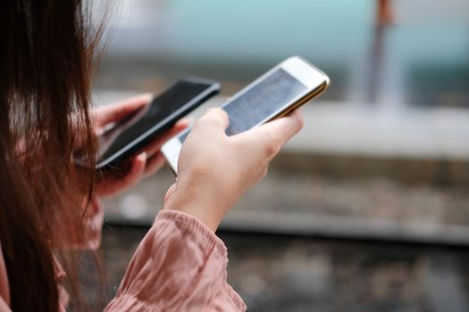 young woman traveler using mobile smart phone at train station. Travel journey trip concept