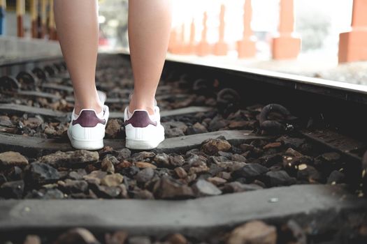 young woman traveler with white sneakers at train station. journey trip travel concept