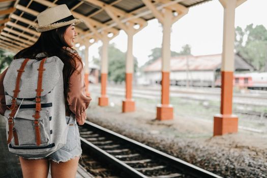 young asian woman  backpacker traveler with backpack at train station. journey trip travel concept