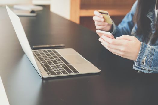 woman holding credit card using computer for shopping online