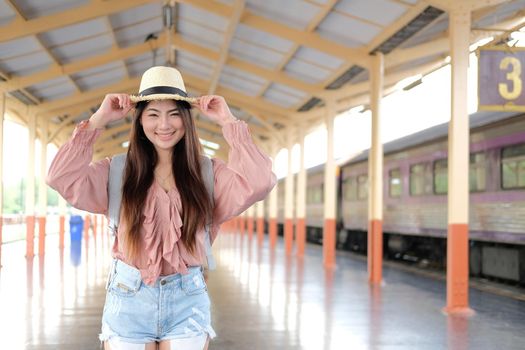 young asian woman  backpacker traveler with backpack at train station. journey trip travel concept