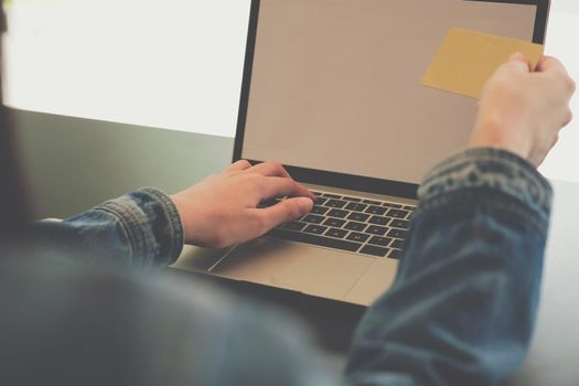 woman holding credit card using computer for shopping online