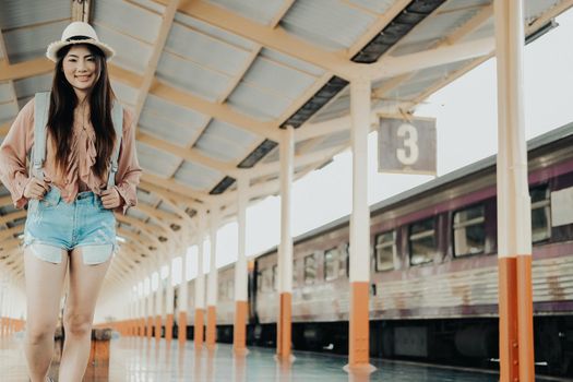 young asian woman  backpacker traveler with backpack at train station. journey trip travel concept