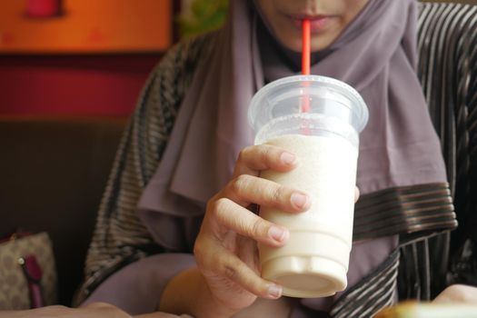 young women drinking banana milk shake at cafe .