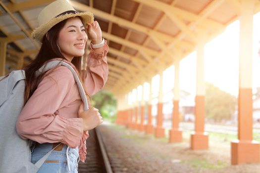 young asian woman  backpacker traveler with backpack at train station. journey trip travel concept