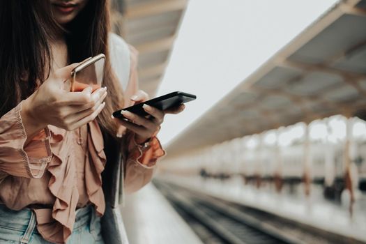 young woman traveler using mobile smart phone at train station. Travel journey trip concept