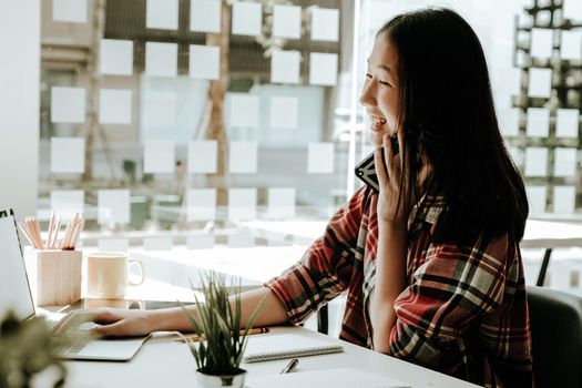 woman girl teenager freelancer talking on phone working on computer at workplace