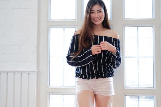 young asian woman in casual clothing posing at home