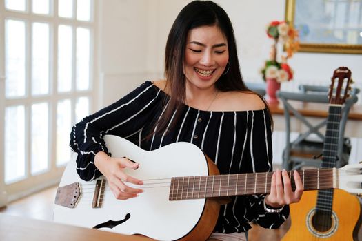 woman playing guitar at home.  leisure lifestyle concept